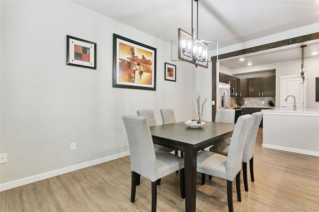 dining room with recessed lighting, baseboards, and light wood finished floors