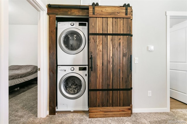 washroom featuring stacked washer / dryer, carpet flooring, laundry area, and baseboards