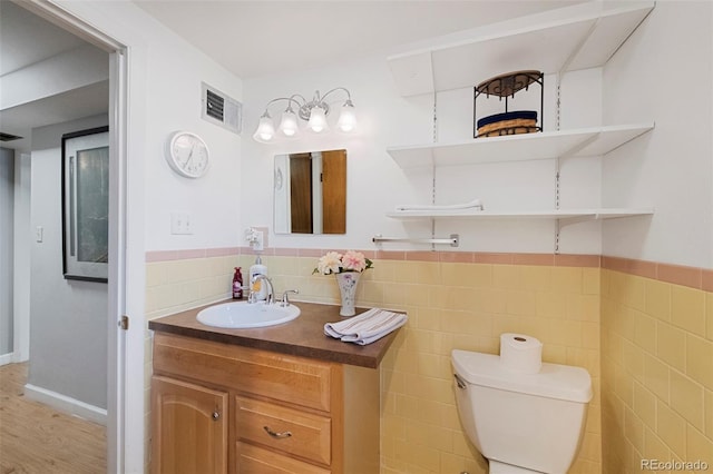6040 Taft Ct, Arvada, CO 80004 - bathroom featuring toilet, tile walls, vanity, wainscoting, and wood finished floors