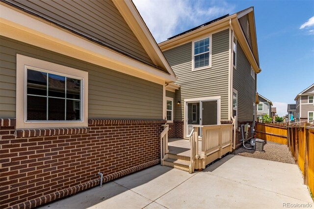 14065 Harrison St, Thornton, CO 80602 - rear view of property with a patio, a deck, and brick siding