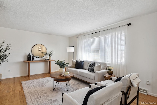 living room featuring a textured ceiling and light wood-type flooring