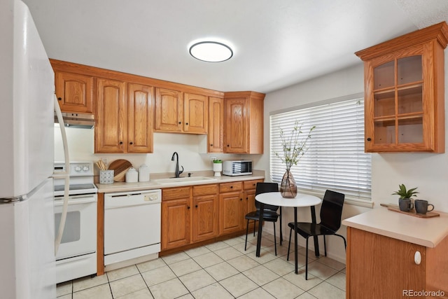 kitchen featuring white appliances, sink, and light tile patterned floors