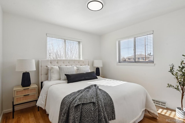 bedroom featuring multiple windows and hardwood / wood-style flooring