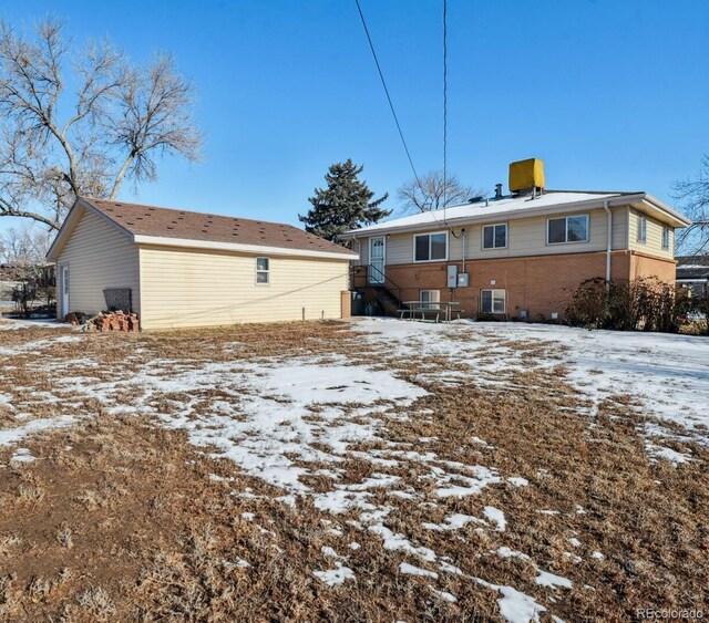 snow covered house featuring cooling unit