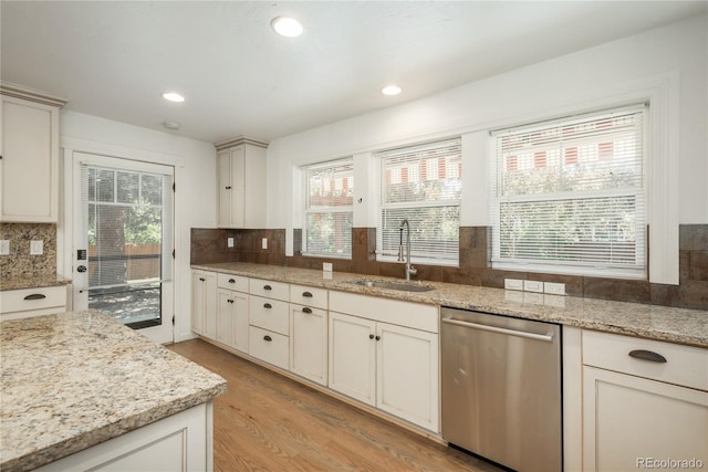 kitchen featuring dishwasher, a sink, tasteful backsplash, light wood-type flooring, and recessed lighting