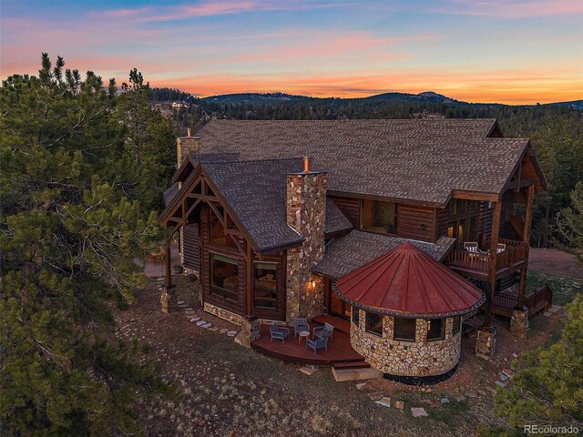 29548 Sunset Trl, Pine, CO 80470 - rear view of house with stone siding, a chimney, and a deck