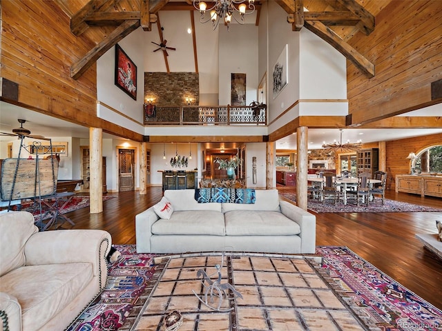 29548 Sunset Trl, Pine, CO 80470 - living area featuring decorative columns, a chandelier, wood walls, hardwood / wood-style floors, and high vaulted ceiling