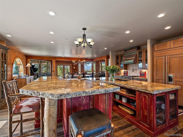 29548 Sunset Trl, Pine, CO 80470 - kitchen with recessed lighting, a large island, an inviting chandelier, reddish brown cabinets, and dark wood-style flooring