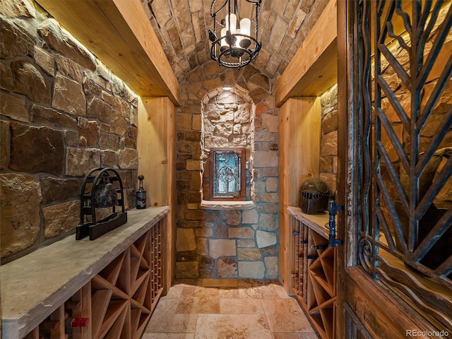 29548 Sunset Trl, Pine, CO 80470 - wine room with brick ceiling, vaulted ceiling, stone tile floors, and a notable chandelier