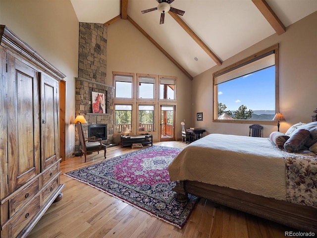 29548 Sunset Trl, Pine, CO 80470 - bedroom featuring hardwood / wood-style floors, a stone fireplace, beamed ceiling, high vaulted ceiling, and multiple windows