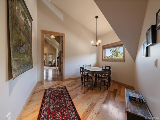 29548 Sunset Trl, Pine, CO 80470 - dining room with a notable chandelier, baseboards, high vaulted ceiling, and light wood-style floors