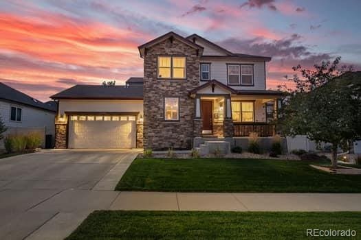 view of front of property with a garage and a lawn