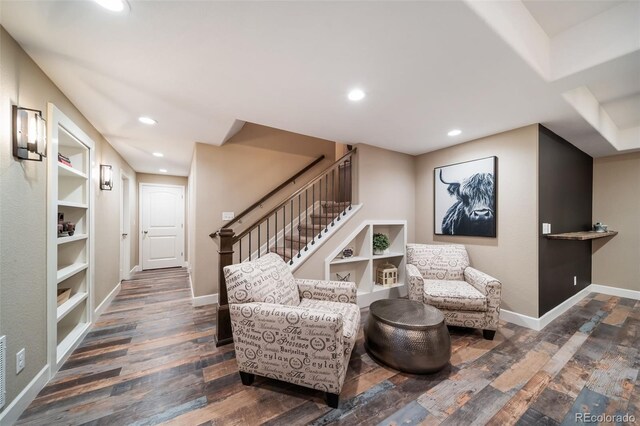 living area featuring built in shelves and dark hardwood / wood-style floors