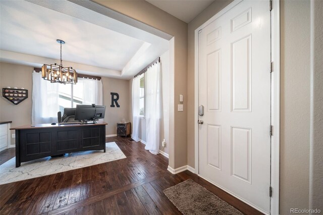 foyer entrance featuring an inviting chandelier and dark hardwood / wood-style floors