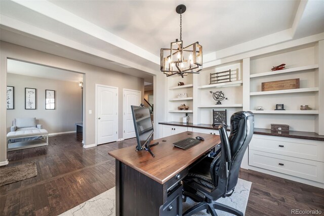 office with built in desk, a chandelier, and dark hardwood / wood-style flooring