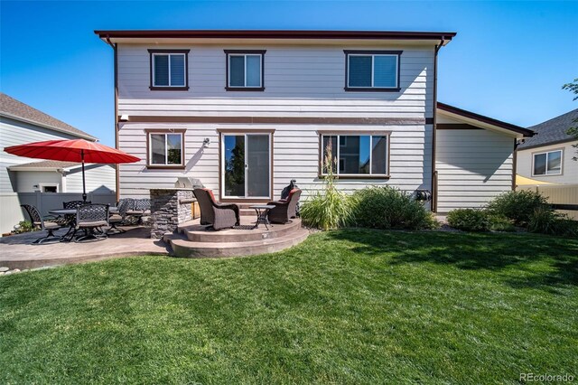 rear view of house with exterior kitchen, a lawn, and a patio