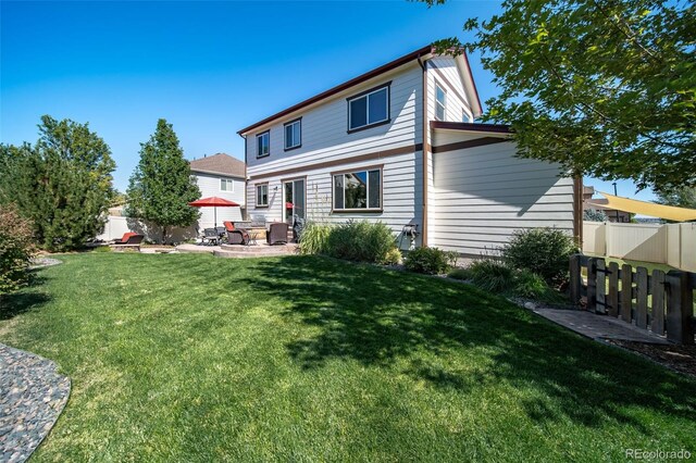 back of house featuring a patio area and a yard