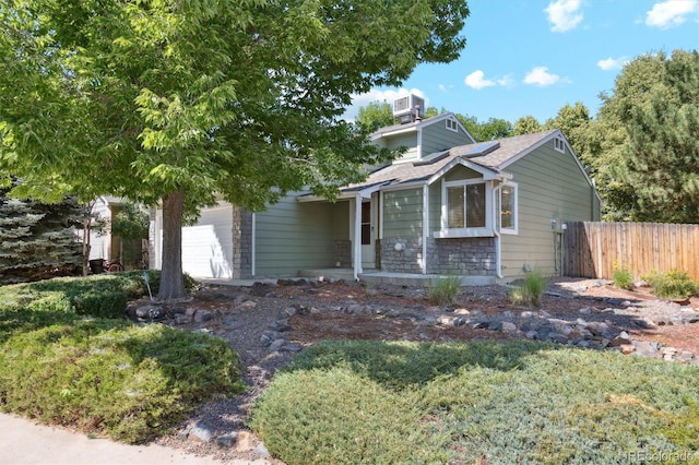 4947 S Espana Way, Centennial, CO 80015 - view of front of house featuring stone siding, roof mounted solar panels, and a garage