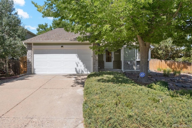 4947 S Espana Way, Centennial, CO 80015 - view of front of house with stone siding, an attached garage, driveway, and a shingled roof