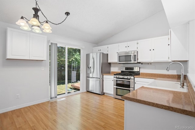 4947 S Espana Way, Centennial, CO 80015 - kitchen with stainless steel appliances, a chandelier, white cabinets, light wood-type flooring, and lofted ceiling