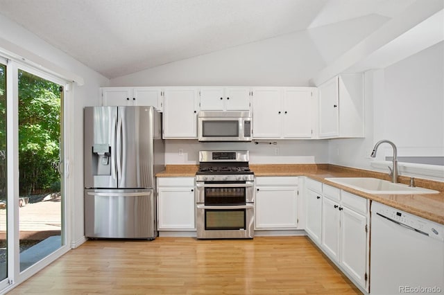 4947 S Espana Way, Centennial, CO 80015 - kitchen with stainless steel appliances, white cabinets, lofted ceiling, light wood finished floors, and light countertops