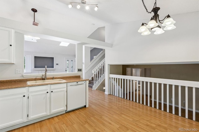 4947 S Espana Way, Centennial, CO 80015 - kitchen featuring dishwasher, a chandelier, white cabinets, vaulted ceiling, and light wood finished floors