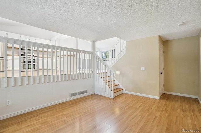 4947 S Espana Way, Centennial, CO 80015 - empty room with wood finished floors, a textured ceiling, stairway, and a smoke detector