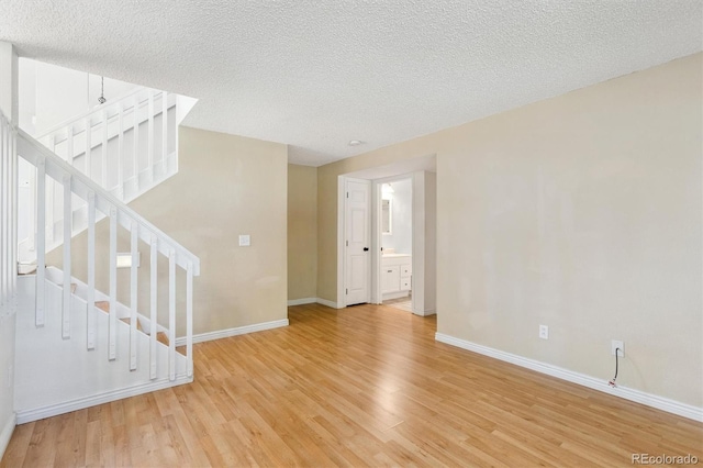 4947 S Espana Way, Centennial, CO 80015 - unfurnished room featuring light wood-type flooring, stairs, and a textured ceiling