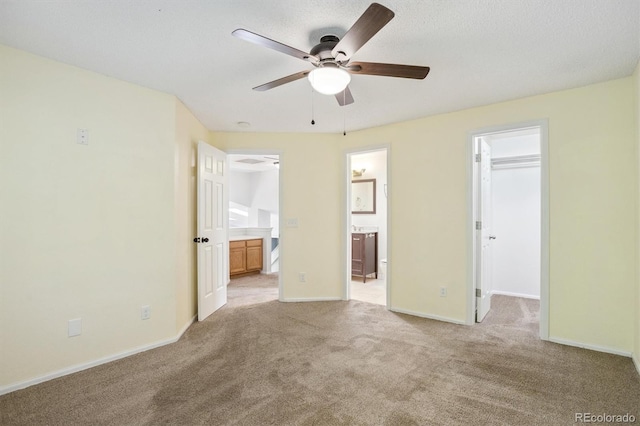 4947 S Espana Way, Centennial, CO 80015 - unfurnished bedroom with a spacious closet, ensuite bathroom, light carpet, and ceiling fan
