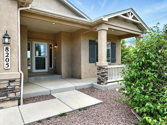 8205 Birch Tree Loop, Colorado Springs, CO 80927 - entrance to property with stucco siding, stone siding, and a porch