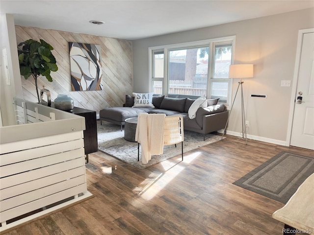 living room with dark hardwood / wood-style floors and wooden walls