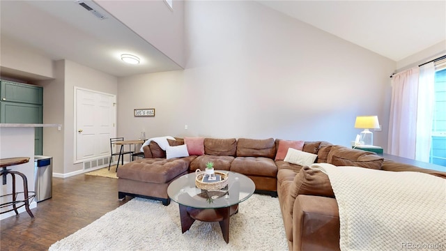 living room featuring dark wood-type flooring and vaulted ceiling