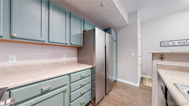 kitchen featuring wood-type flooring, appliances with stainless steel finishes, and sink