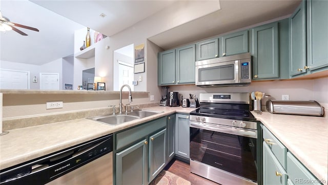 kitchen featuring ceiling fan, stainless steel appliances, sink, and light wood-type flooring