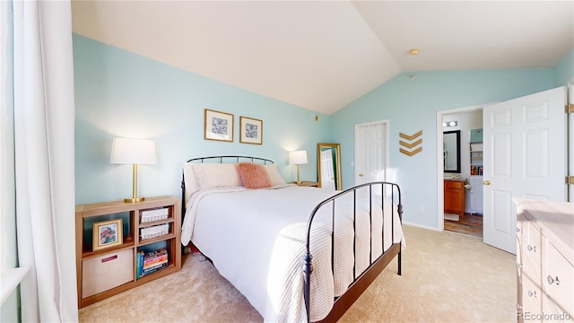 carpeted bedroom with connected bathroom and vaulted ceiling