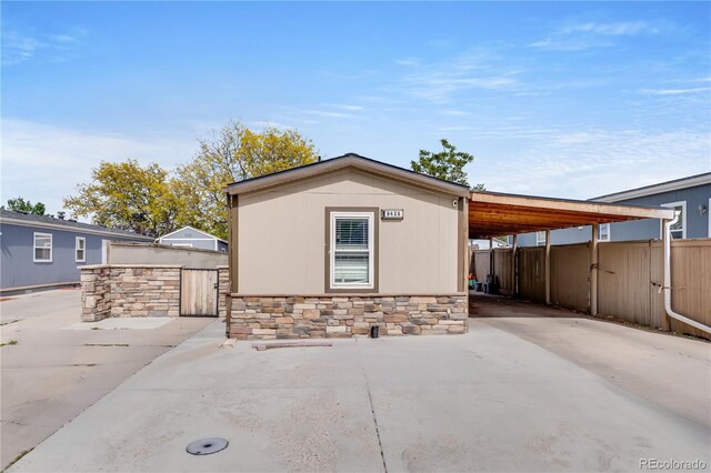 8426 Cook Way, Denver, CO 80229 - view of front facade featuring an attached carport, driveway, and stone siding