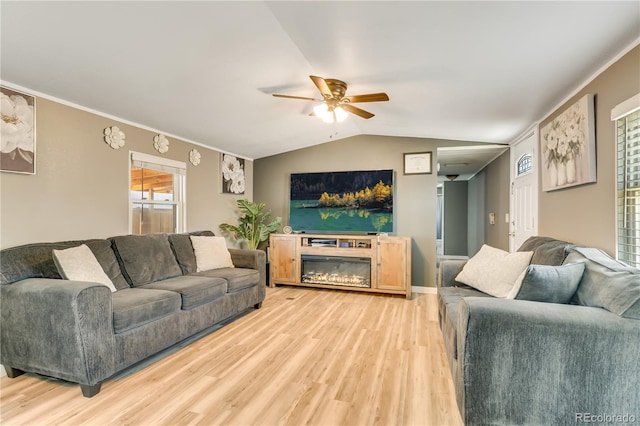 8426 Cook Way, Denver, CO 80229 - living room featuring a ceiling fan, light wood finished floors, lofted ceiling, ornamental molding, and a glass covered fireplace