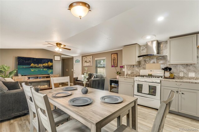 8426 Cook Way, Denver, CO 80229 - dining space featuring light wood finished floors, a ceiling fan, lofted ceiling, and a glass covered fireplace