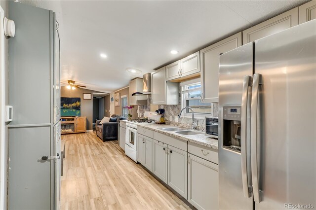 8426 Cook Way, Denver, CO 80229 - kitchen featuring white appliances, wall chimney exhaust hood, light wood-type flooring, light countertops, and open floor plan