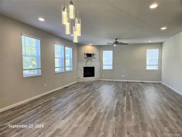 unfurnished living room featuring ceiling fan, dark wood-type flooring, and a textured ceiling