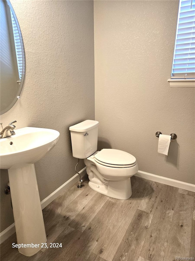 bathroom featuring wood-type flooring and toilet