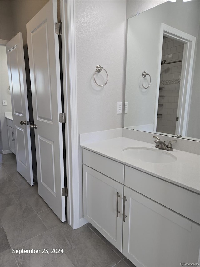 bathroom featuring tile patterned floors, vanity, and tiled shower