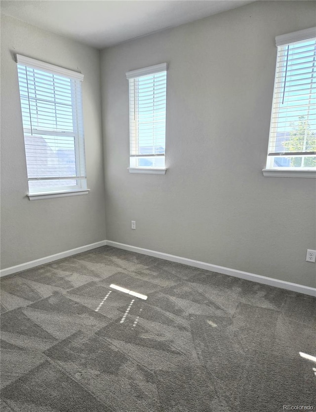 carpeted spare room with a healthy amount of sunlight