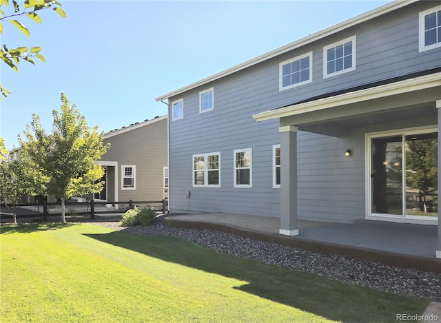 back of property featuring a patio and a yard