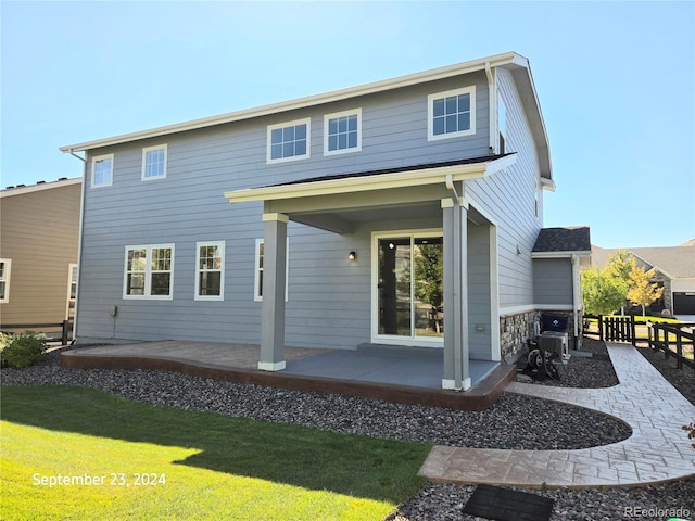 back of property featuring a patio and a lawn