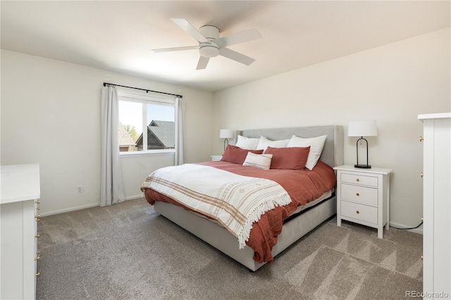 bedroom featuring light colored carpet, a ceiling fan, and baseboards