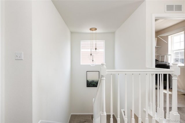 stairway featuring baseboards and visible vents