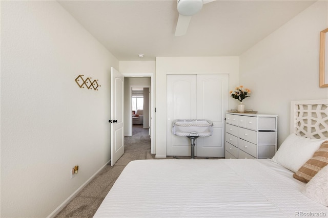 bedroom with a ceiling fan, baseboards, carpet, and a closet