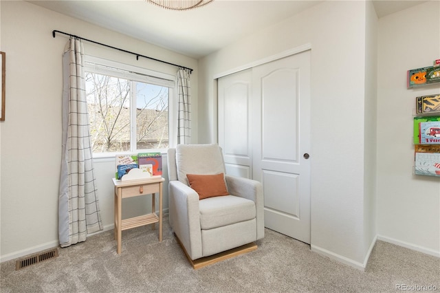 living area with visible vents, baseboards, and carpet floors