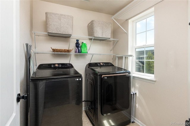 laundry area with baseboards, laundry area, and washing machine and dryer